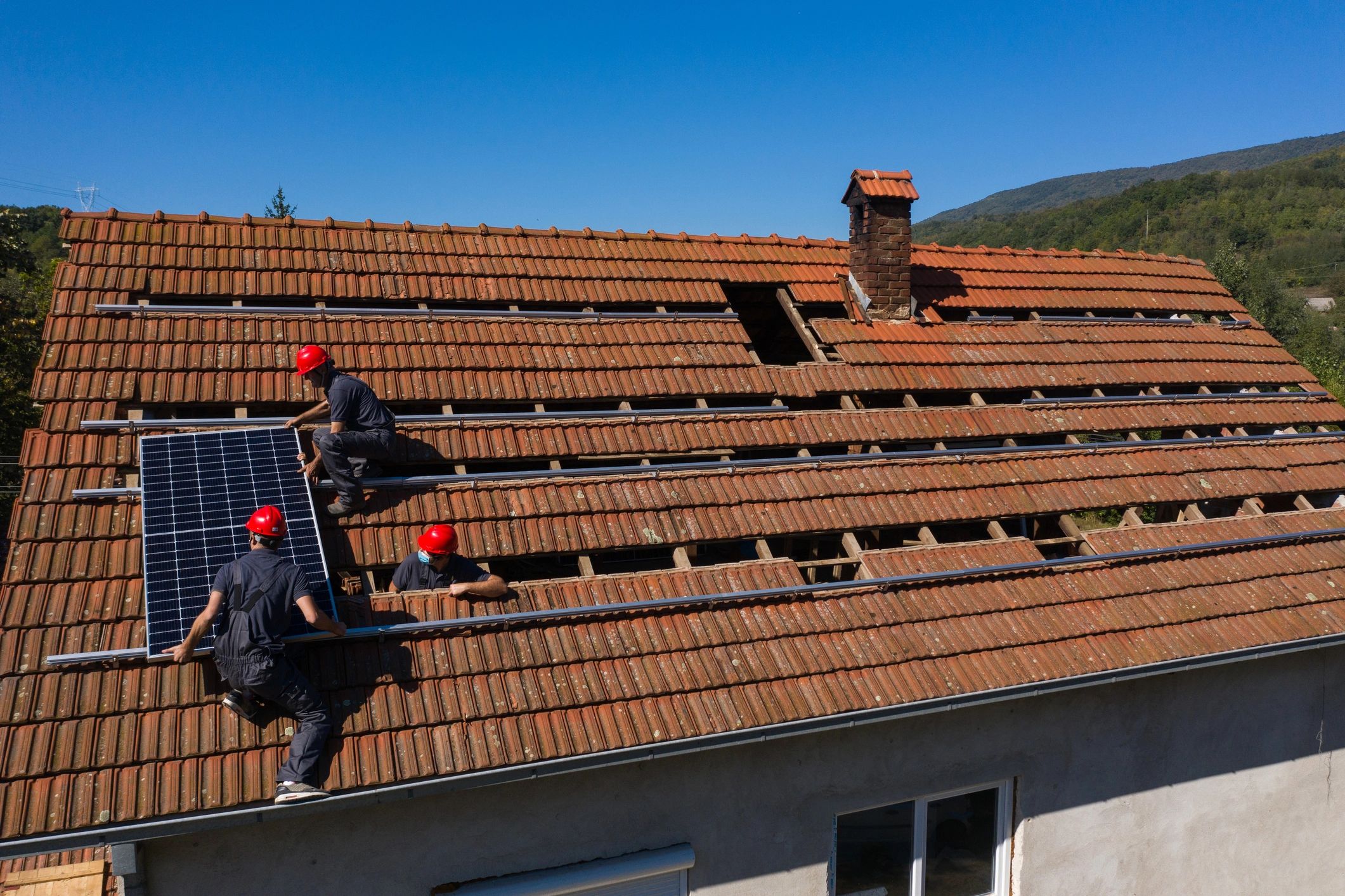 Crew performing exterior work on a residential roof