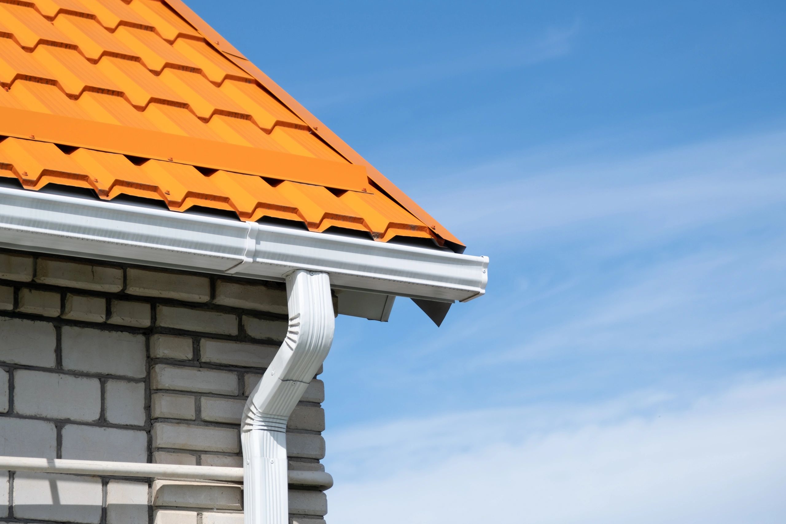 Residential gutter system installed along a brick home
